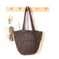 Dark coffee paper straw shoulder bag with rounded body hanging on a wall rack