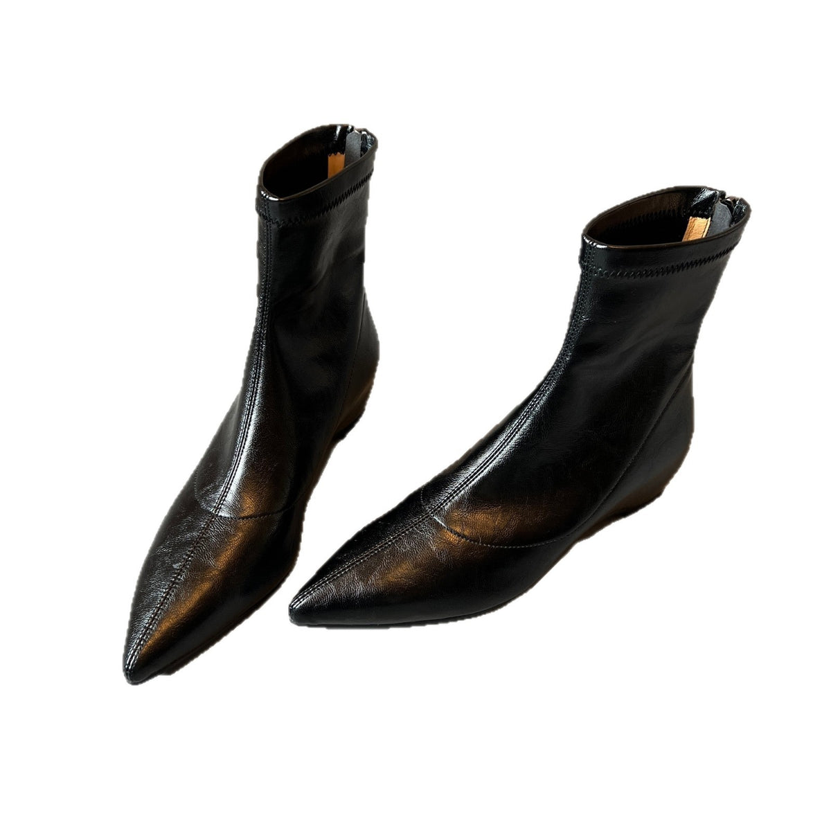 Pair of black pointed toe ankle boots with a back zip on a white background