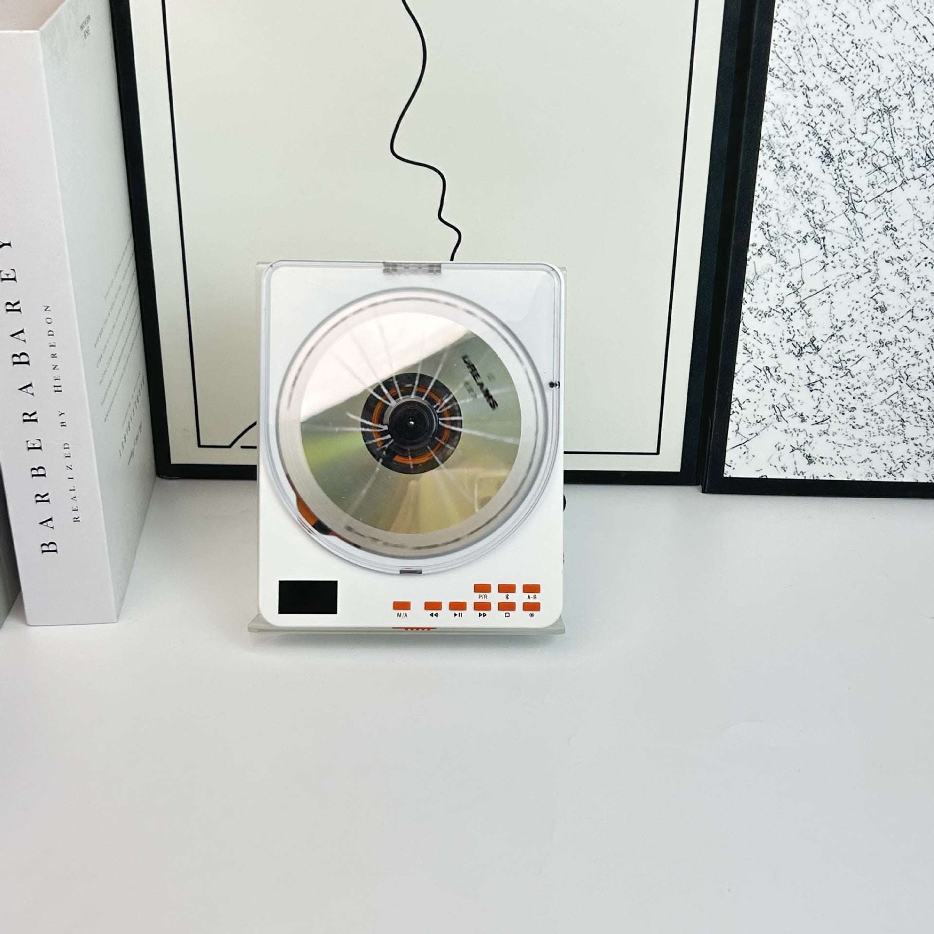 White portable CD player standing on a desk with a disc loaded under the lid