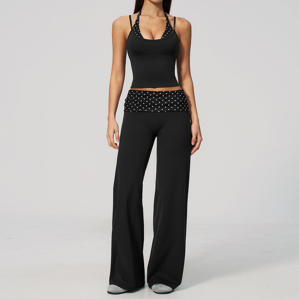 Model in a cropped camisole and wide leg fold over waist pants set, black with white polka dots