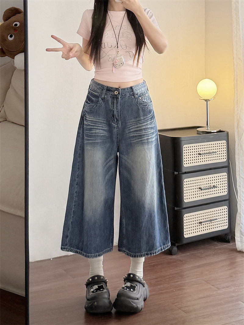 Woman in high waist wide-leg cropped blue denim jeans, front mirror view