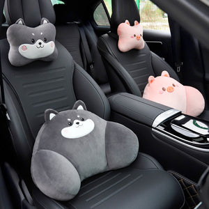 Gray dog headrest and lumbar pillows on a front car seat, with pink pig pillows on the rear seat