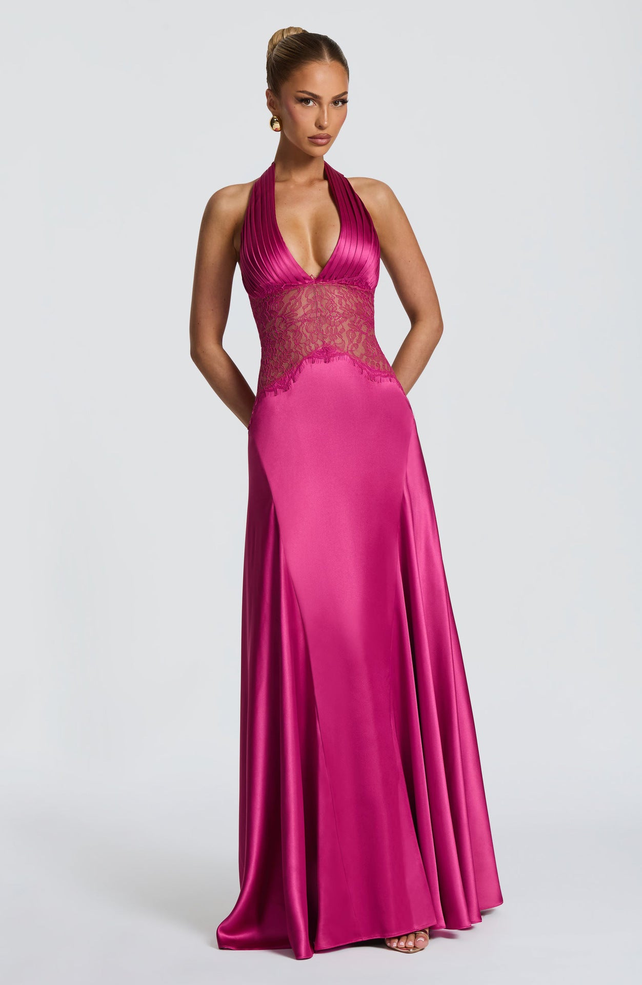 Magenta satin halter gown with pleated bodice and sheer floral lace waist, studio