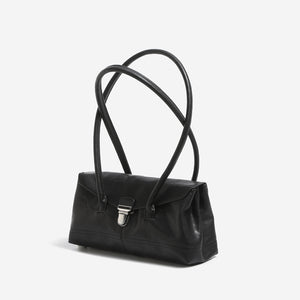 Black PU baguette shoulder bag with covered flap and crossed long handles, three quarter view