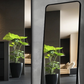 Two framed rectangular mirrors in black showing portrait hanging against a dark wall