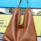 Genuine leather bucket tote bag shown front with shoulder strap