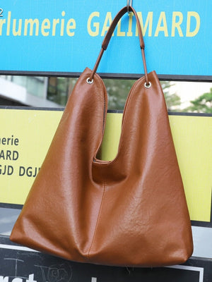 Genuine leather bucket tote bag shown front with shoulder strap