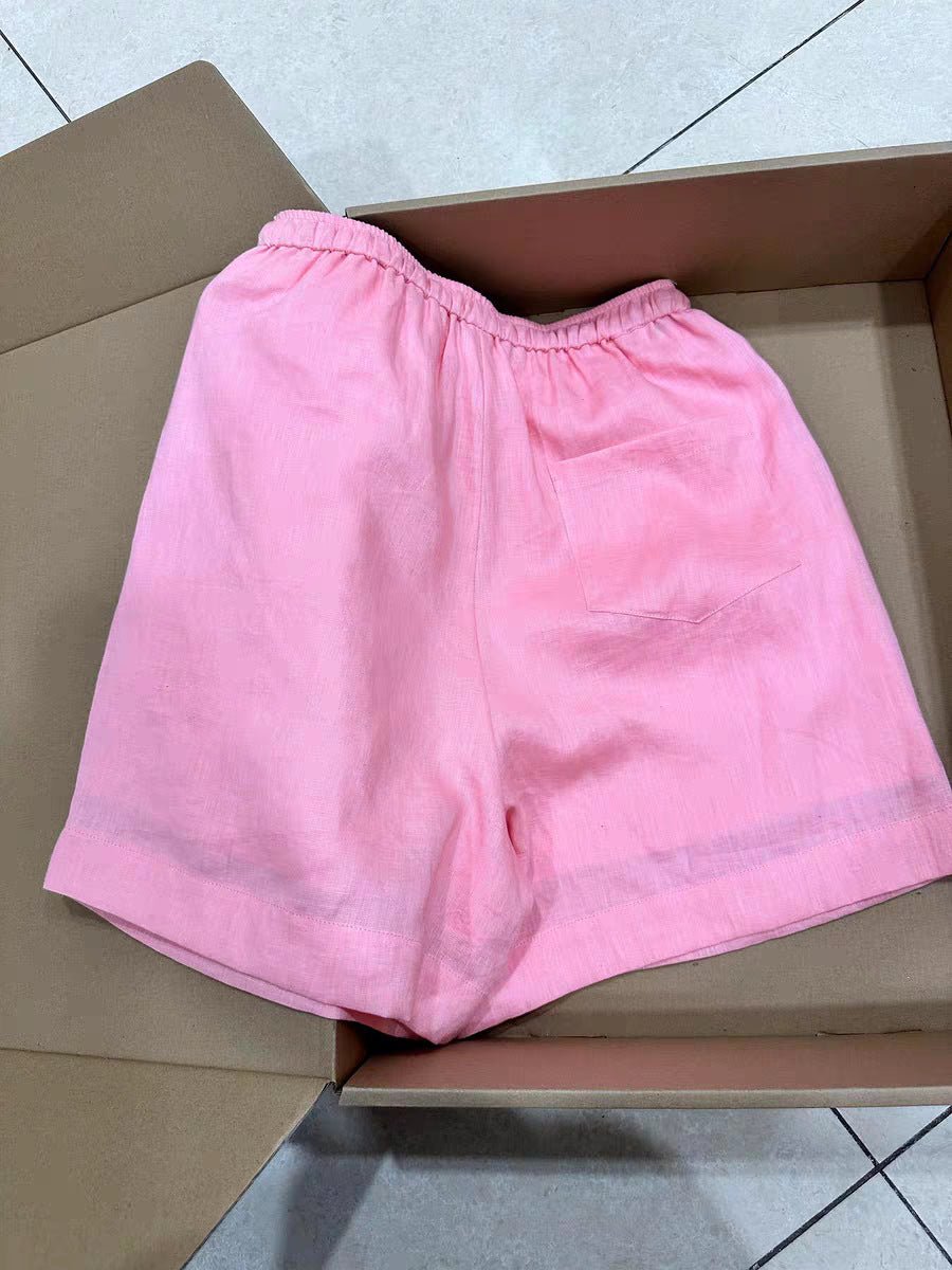 Pink linen shorts back view showing patch pocket and deep turned-up leg hem