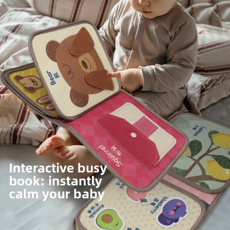 Baby holding the soft sensory cloth book during tummy time play