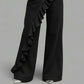 Black wide leg denim trousers with a cascading ruffle and a mid rise waist over pointed shoes