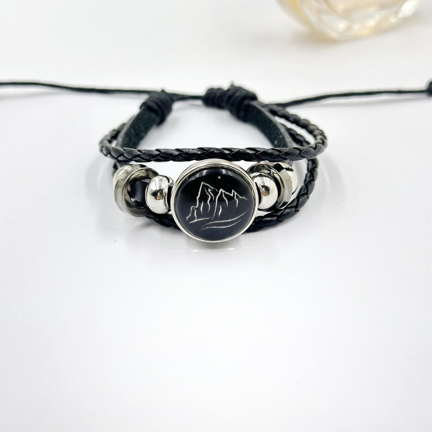 Pink braided cord bracelet with a sun charm and sliding knot closure