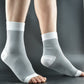 White nylon knit compression foot sleeves worn on both feet, side view, open toe and ribbed ankle cuff