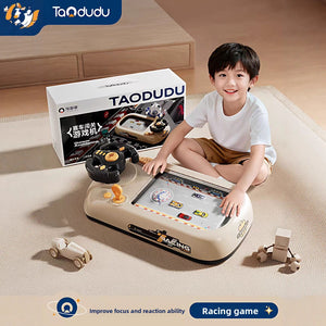 Child playing a tabletop racing game with a steering wheel beside its gift box