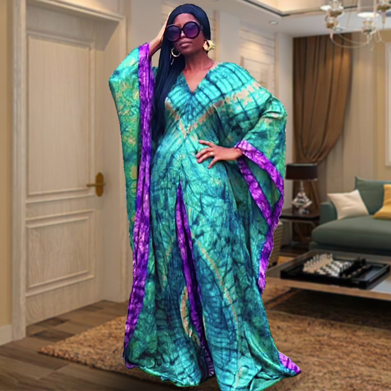 Model in the teal and purple tie dye satin caftan gown, floor length with wide sleeves
