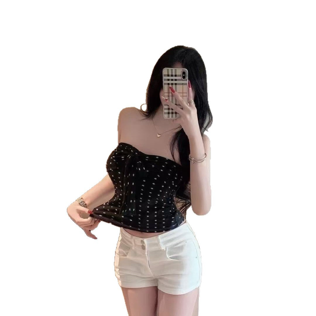 Model lifts the black floral bandeau top hem, showing the cropped length over white shorts