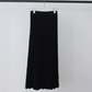 Black ribbed knit skirt with knit waistband hanging on a white hanger