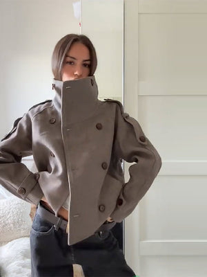 Side view of the taupe double breasted wool blend coat showing epaulettes and cuff tabs