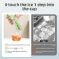 Hand pressing the orange handle of the clear tube ice tray, cubes releasing straight into a tall glass