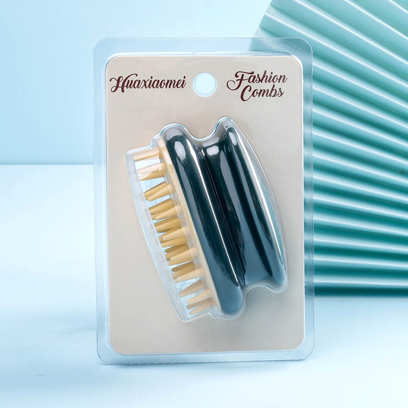 Dark silicone scalp shampoo brush on a blister card with soft cream bristles