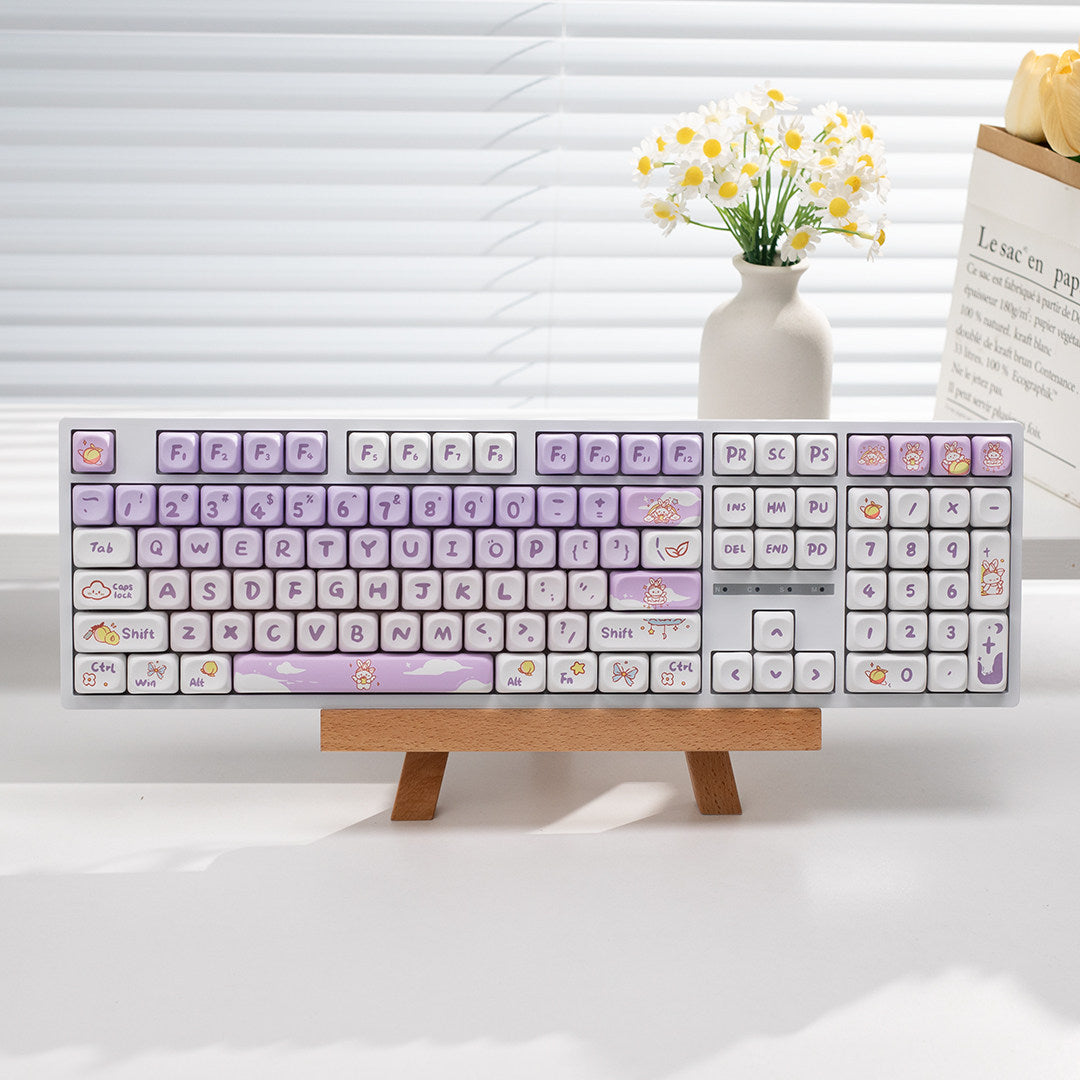 Full-size 108-key mechanical keyboard with lilac purple rabbit keycaps on a wooden stand