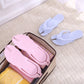 Light blue folding flip flops and pink pair packed in a storage box with towels