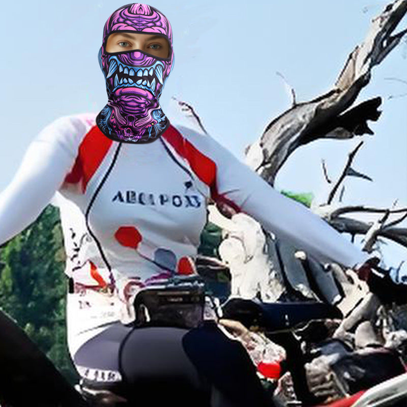 Rider on a bike trail wearing the purple monster print balaclava over a white long sleeve top
