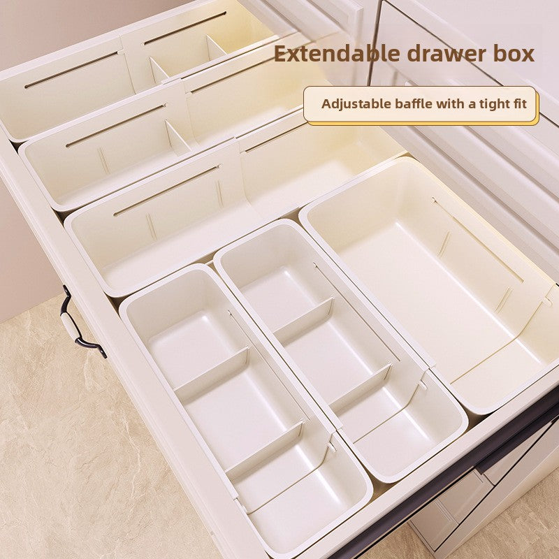 White plastic extendable drawer organizer boxes with sliding dividers arranged inside an open drawer