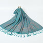 Teal green paisley jacquard scarf spread on a white background with twisted teal tassel fringe