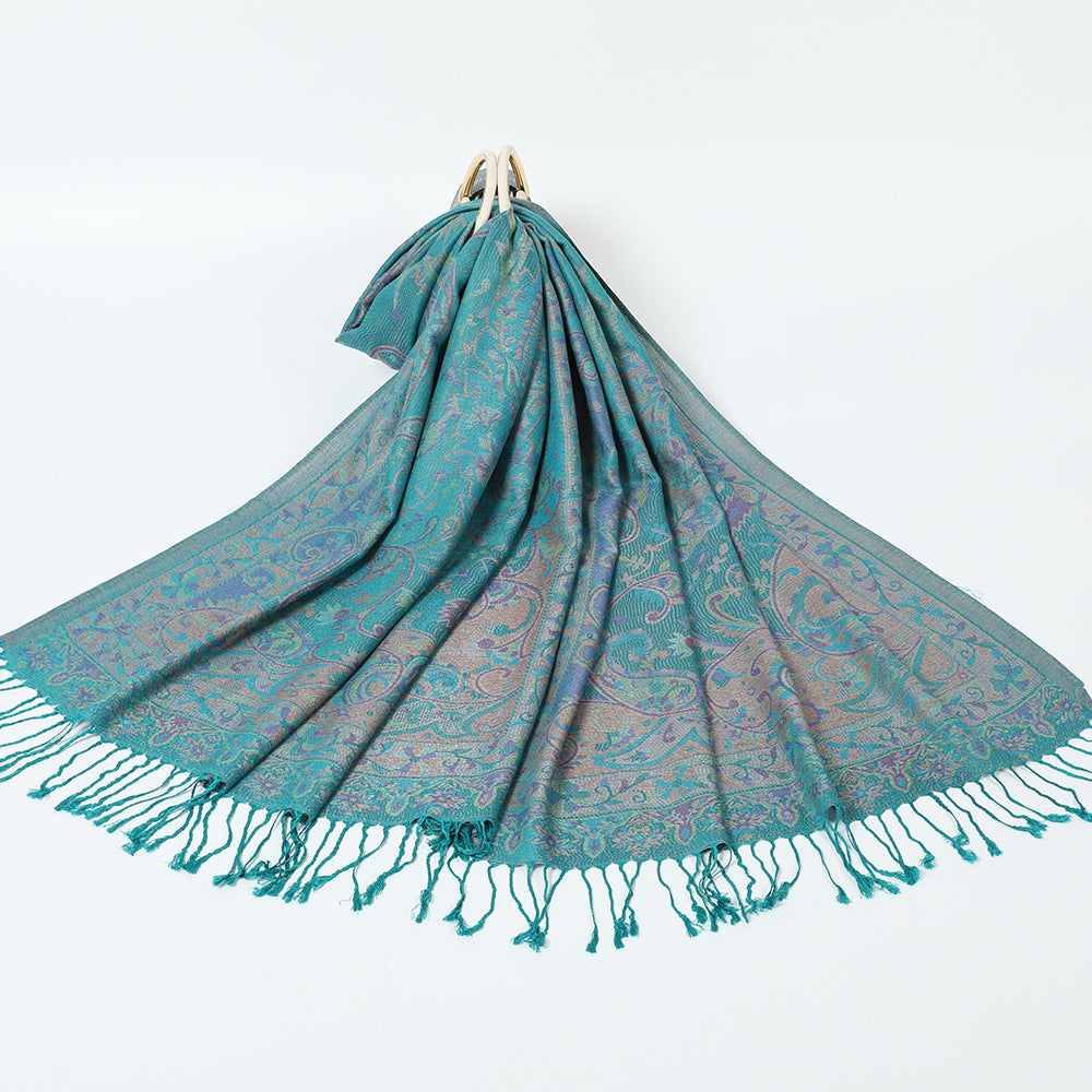 Teal green paisley jacquard scarf spread on a white background with twisted teal tassel fringe