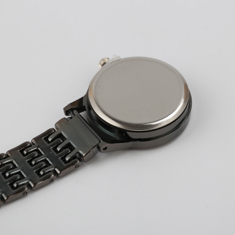 Back of the nurse fob watch showing the flat bar with a brooch pin and the case back