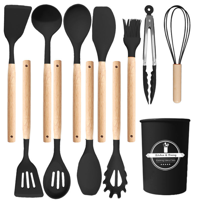 Full black utensil set displayed flat, from turners and spoons to tongs, whisk and holder