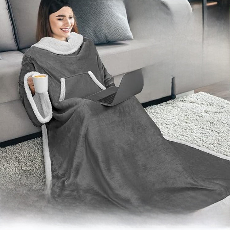 Woman seated with a laptop and mug wearing a gray sleeved blanket with a sherpa edged kangaroo pocket
