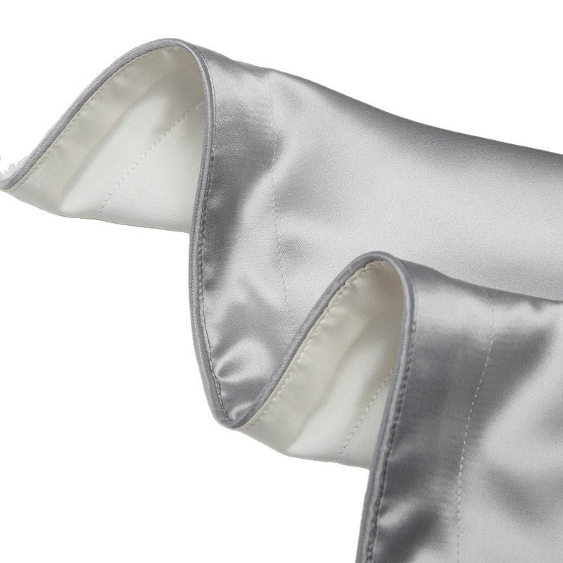 Silk pillowcase with a contrast piped border shown on a smooth white bed