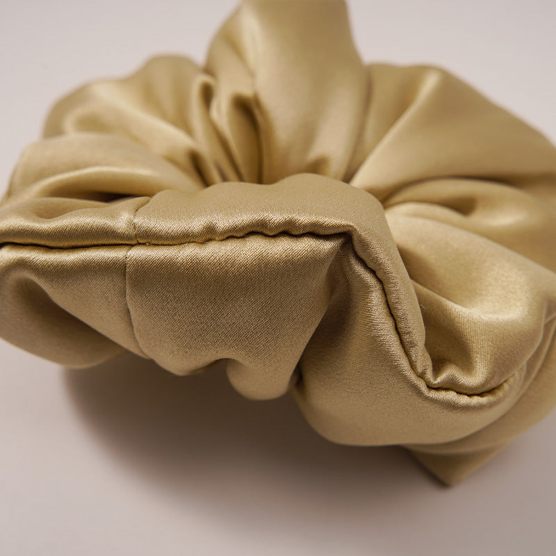 Black satin hair scrunchie on a light surface