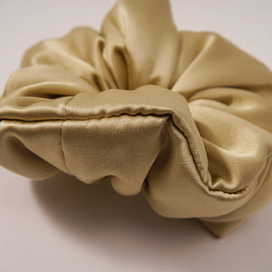 Black satin hair scrunchie on a light surface
