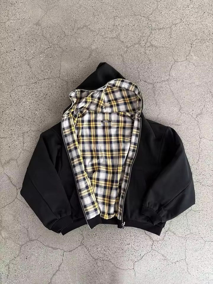 Black reversible zip hooded sweatshirt, solid black outer with a yellow tartan plaid reverse