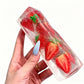 Translucent fruit ice cube squishy toy showing strawberry slices in clear plastic