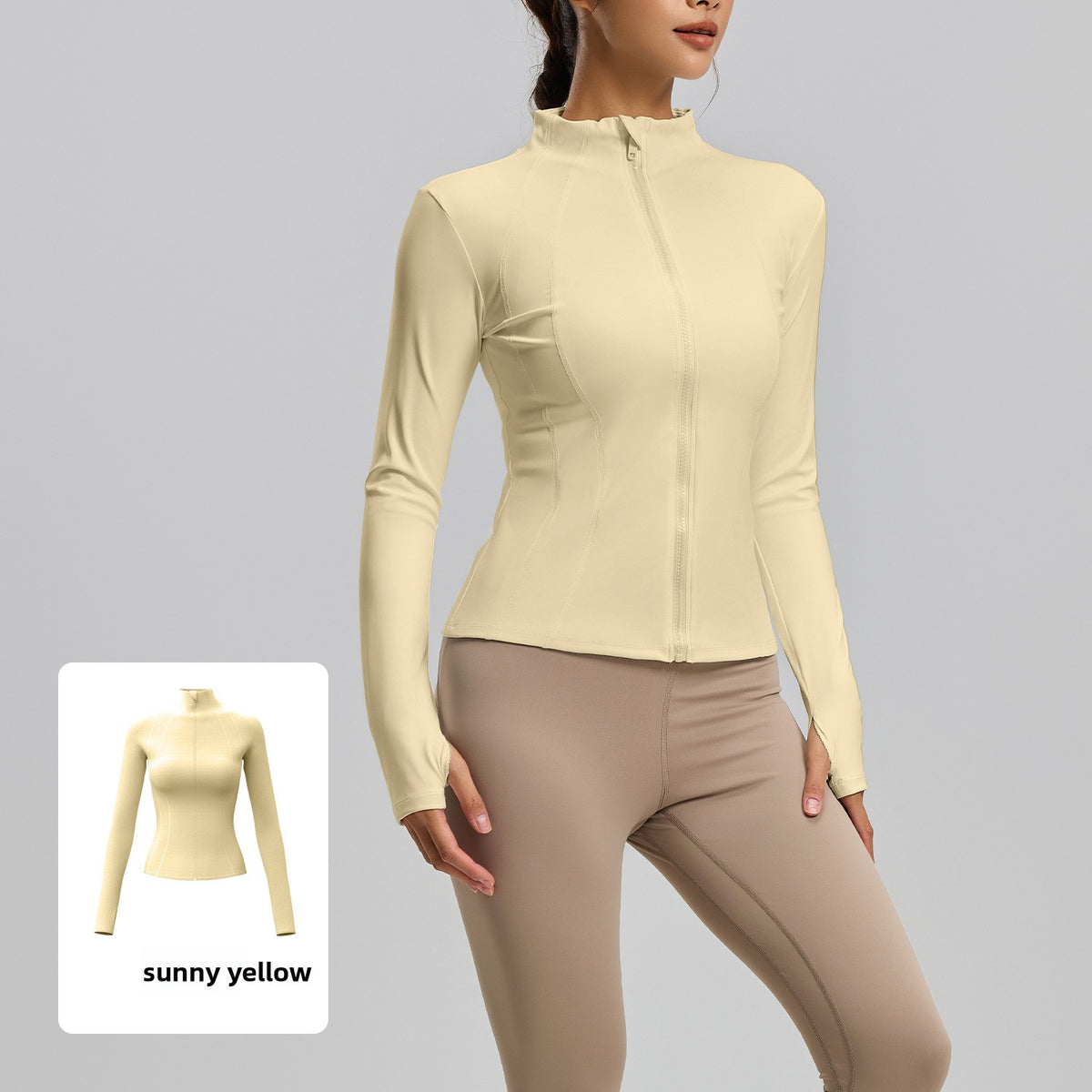 Woman in a pale yellow slim fit stand collar zip jacket with thumb holes, yellow swatch inset at the corner