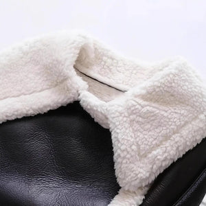 Cropped vegan leather sherpa aviator jacket worn open over a white top, short hem at the waist