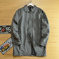 Dark gray mid-length quilted lined coat with lapel collar and covered button front on a hanger, size XXL option