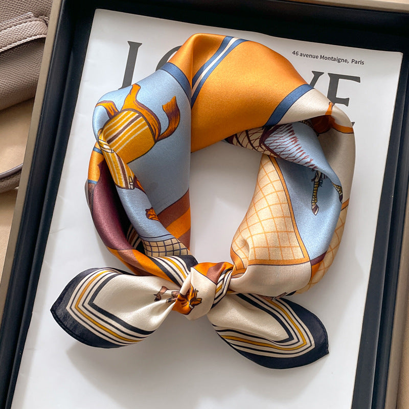Orange and blue paisley printed square scarf with a satin sheen and hemmed edges, shown displayed