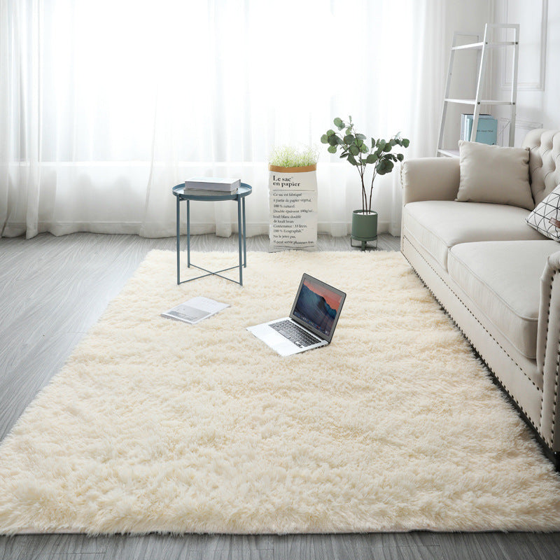 Shaggy polyester area rug in a modern interior beside light wood furniture