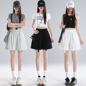 Three women in washed cotton wide-leg shorts in gray, black and white with cropped tops