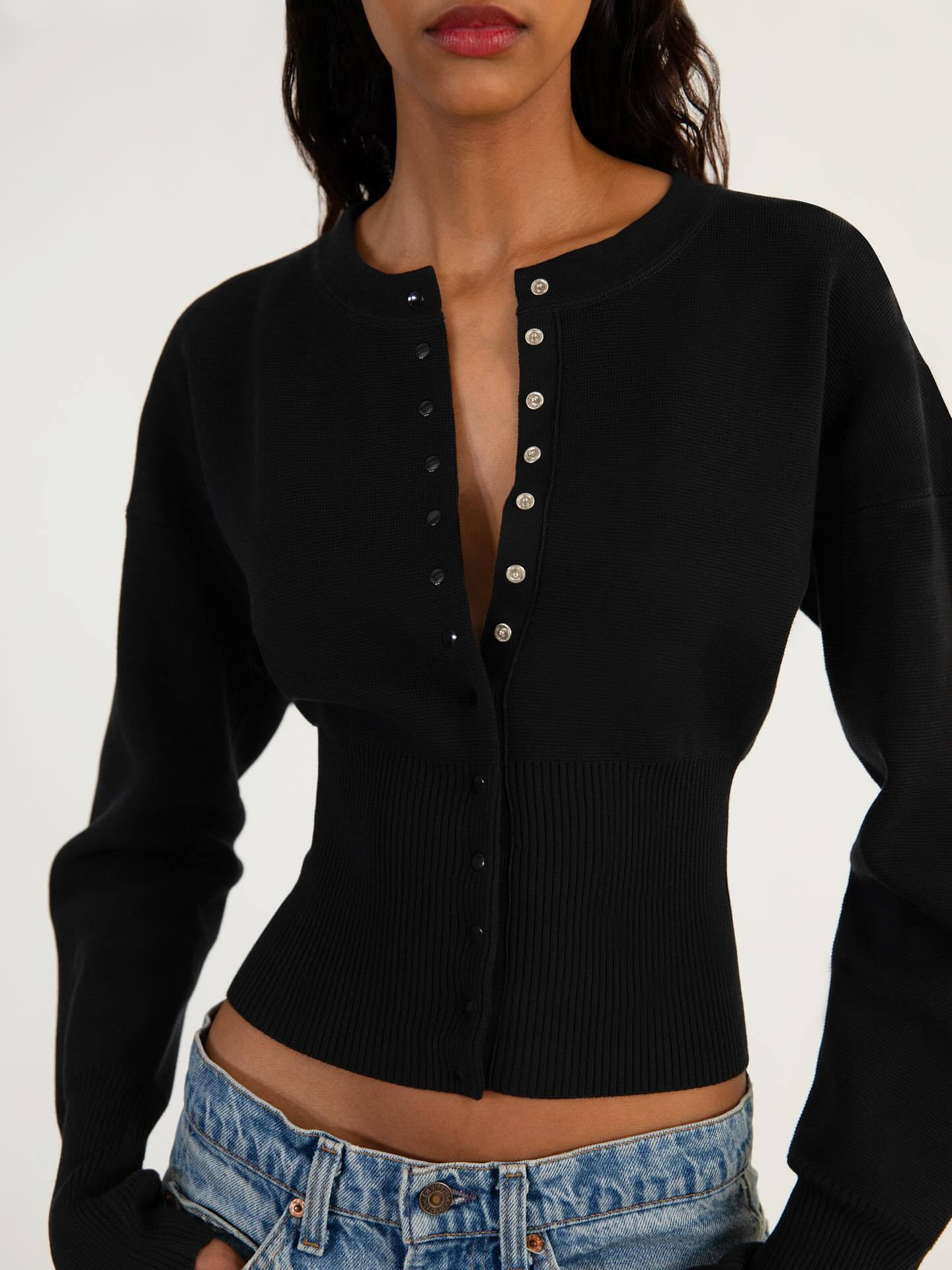Rib knit cardigan laid flat showing the button front and ribbed body