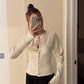 Grey rib knit cardigan shown buttoned to the hem on a model