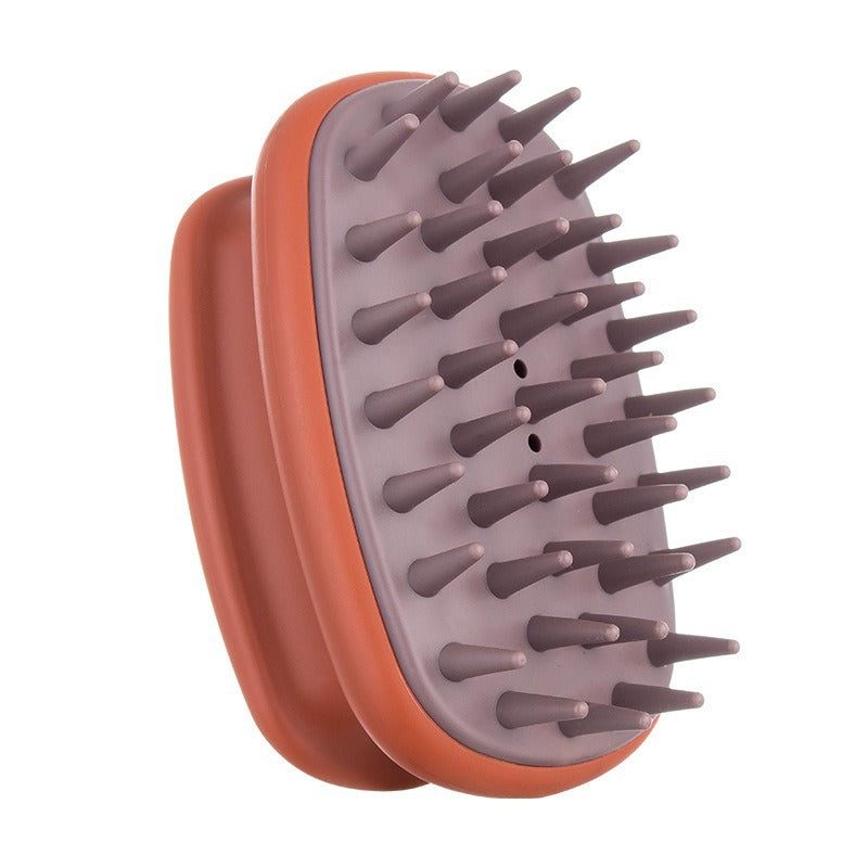 Terracotta and mauve elliptical silicone scalp shampoo brush held in a hand