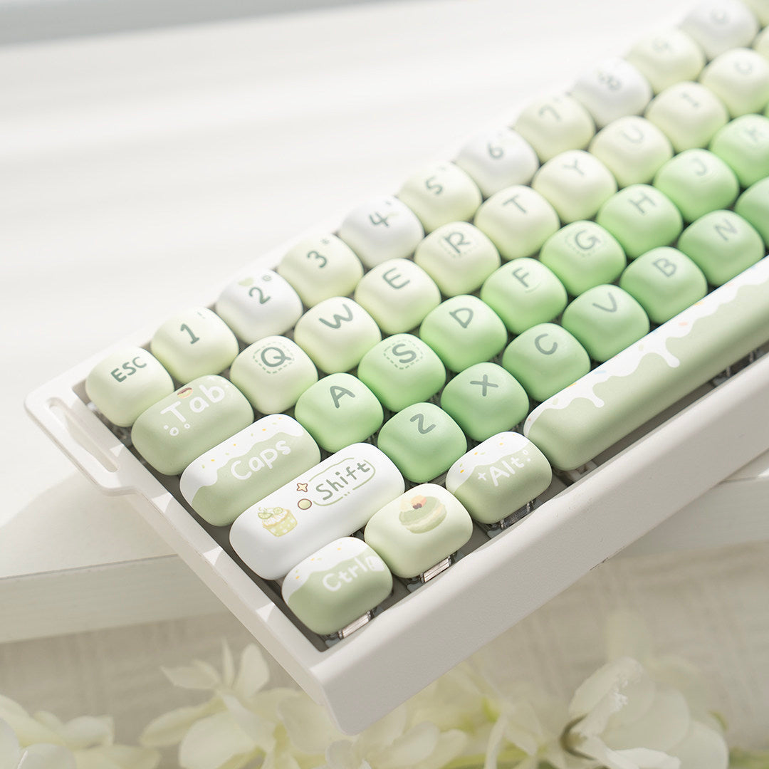 Matcha green M68 mechanical keyboard with rounded MOA keycaps on a white desk