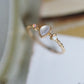 Close-up of the teardrop cabochon and round opal accents on a slim gold-tone band