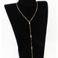 Gold tone rhinestone lariat necklace draped as a Y drop on a black display bust stand