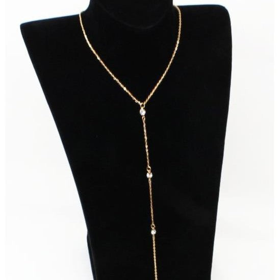 Gold tone rhinestone lariat necklace draped as a Y drop on a black display bust stand